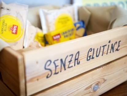 Cassetta di legno con prodotti senza glutine in confezioni colorate.