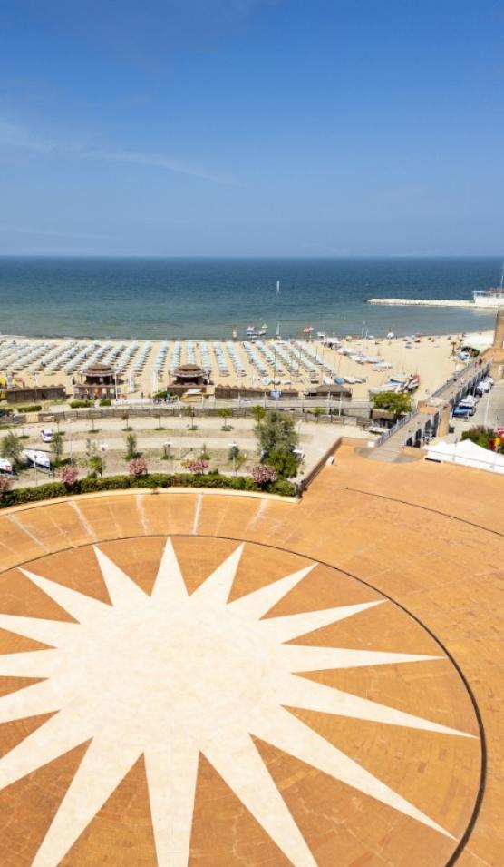 Spiaggia con ombrelloni e piazza con stella, vista sul mare.